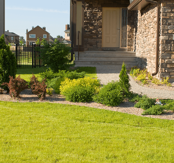 Stone house with green garden and lawn.